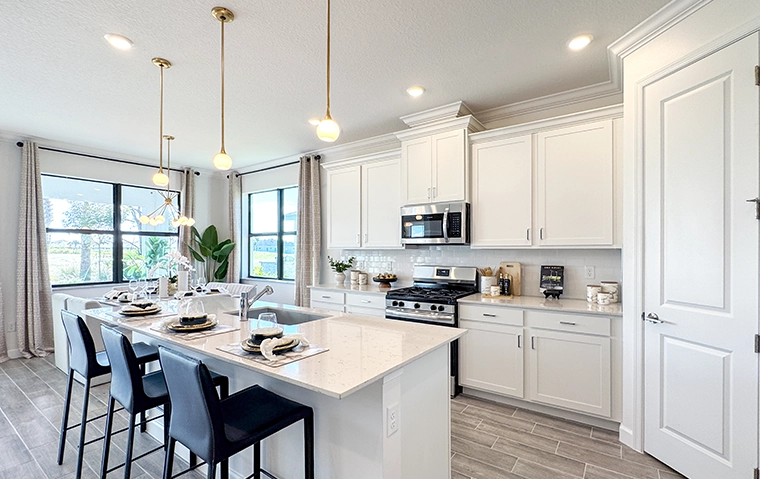 Bright Modern Kitchen with Island Seating Bright modern kitchen with white cabinets, island seating, and pendant lighting.