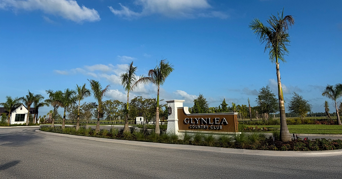 Entrance monument sign for Glynlea Country Club with palm trees and landscaped surroundings.