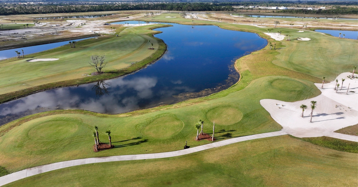 Aerial view of golf course with water, greens and bunkers.