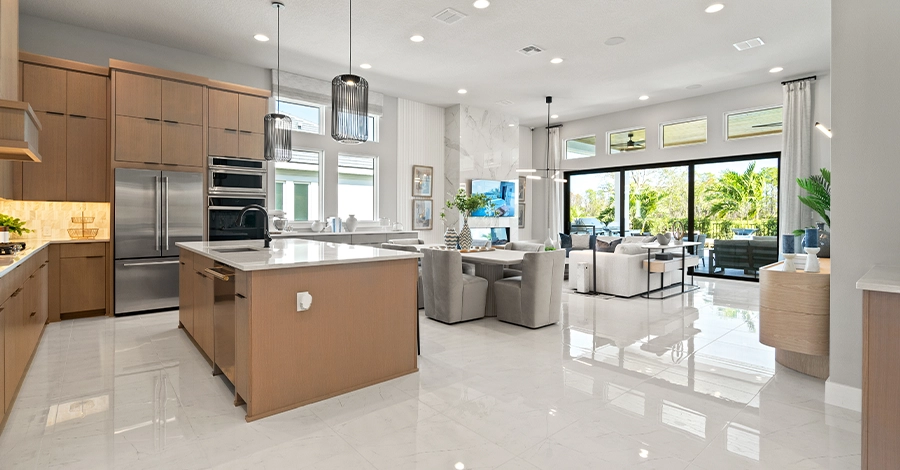 Modern kitchen with island and open living area with large glass doors.