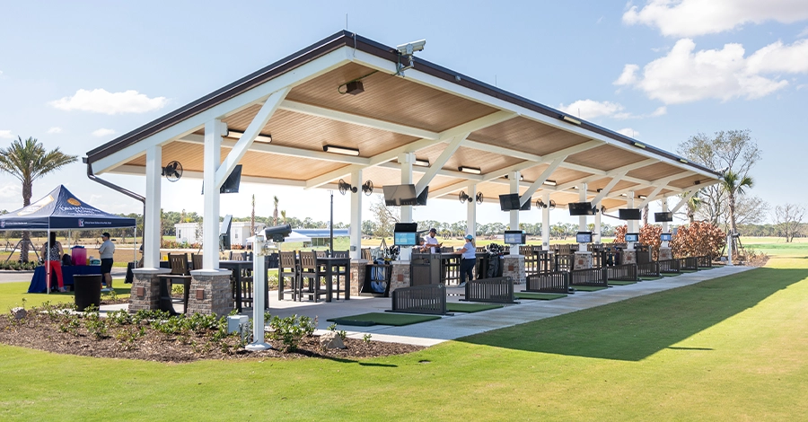 Covered driving range with individual bays and Toptracer monitors.