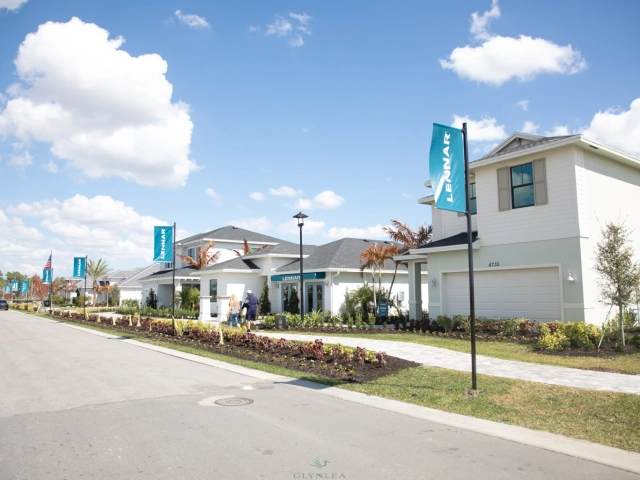 Row of new homes with Lennar flags on landscaped street