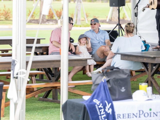 Family sitting at picnic tables outdoors
