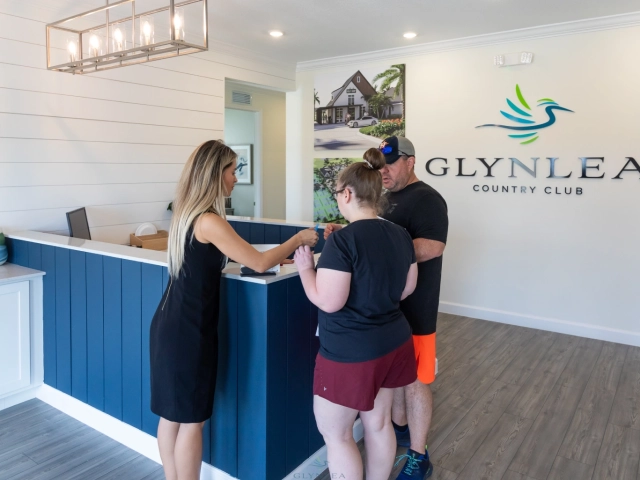 People checking in at clubhouse reception desk
