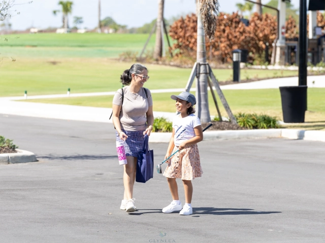Adult and child walking near golf course