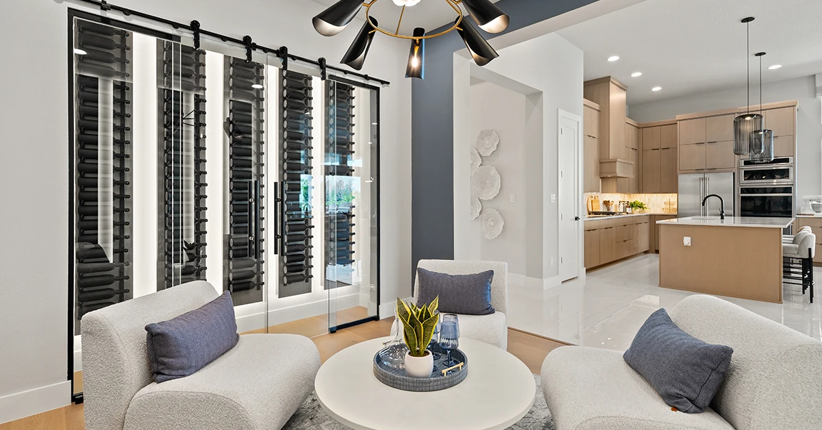 Modern interior with glass wine room, seating area, and open kitchen with cabinetry and lighting